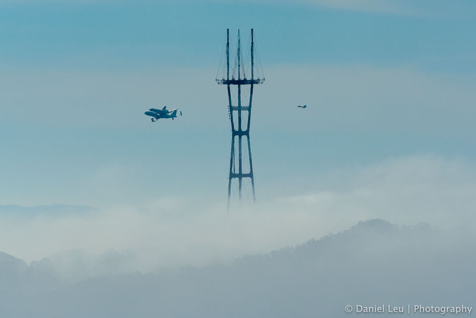 Space Shuttle Endeavour on SCA with fighter escort F-18 passing by Sutro Tower while looping over San Francisco.